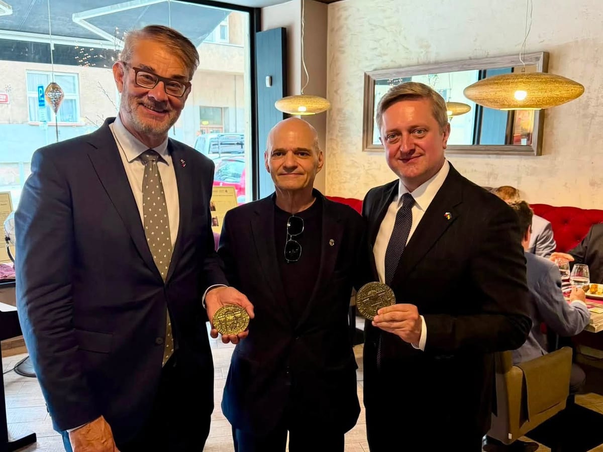 Ambassadors Pasi Tuominen and Vasyl Zvarych holding their Hanno R. Ellenbogen Citizenship Award medals, with Prague Society President Marc S. Ellenbogen